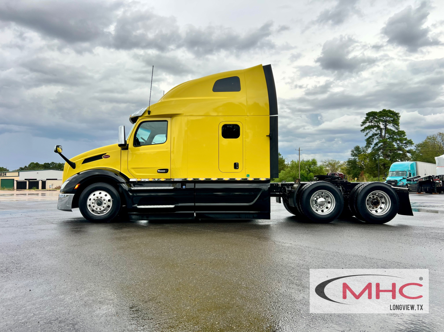 Yellow 2023 Peterbilt 579 conventional sleeper truck side view showing cab and rear wheels, with MHC logo watermark.