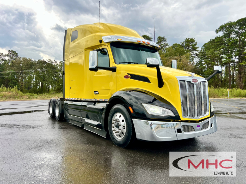 Peterbilt 579 tractor-trailer in yellow, front 3/4 view with chrome bumper and black wheel arches.