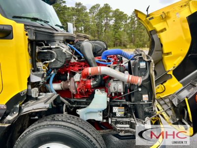 Peterbilt 579 engine bay showing red diesel engine with blue and orange hoses and various components