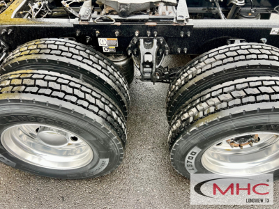 Peterbilt 579 rear dual rear axles showing tires and suspension, with MHC Longview logo partial