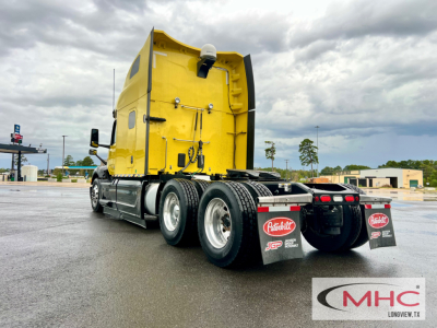 Peterbilt 579 truck rear/side view showing yellow sleeper cab and dual rear axles with mud flaps and Peterbilt logo