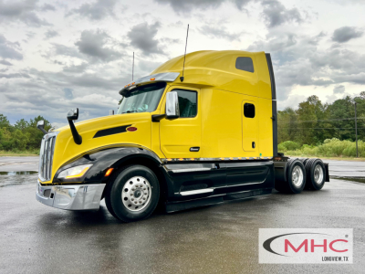 Peterbilt 579 sleeper tractor in yellow, side view showing cab, fuel tanks, dual rear axles, and chrome bumper.