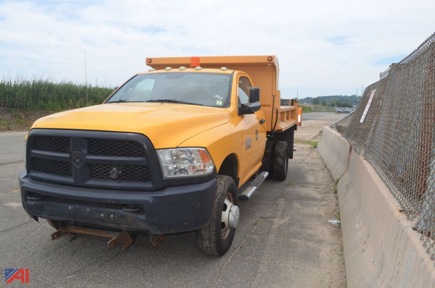 Yellow Ram 3500 dump truck in service bay showing front grille and rear dump bed.