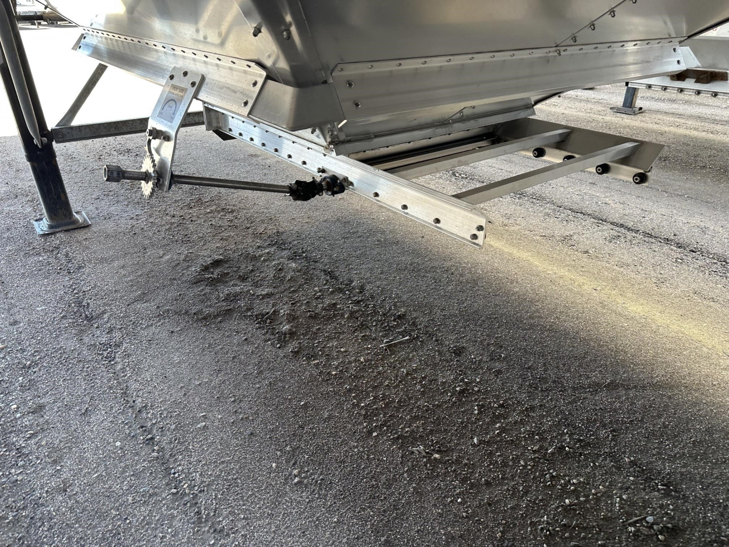 Trailer undercarriage showing support legs and hitch assembly with metal brackets and bolts.