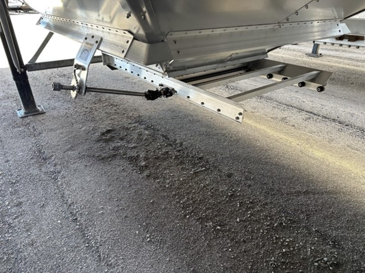 Stoughton grain trailer undercarriage and support frame showing metallic suspension components and rail brackets.