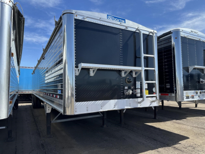 Stoughton 42' grain trailer with 74\" sides and air ride, black rear door, silver aluminum frame, front landing gear, VIN tag area visible.