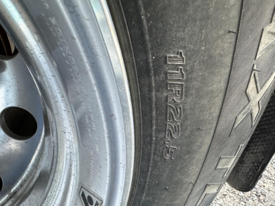 Tire sidewall with markings including 12R22.5 or similar size code visible on a trailer wheel.