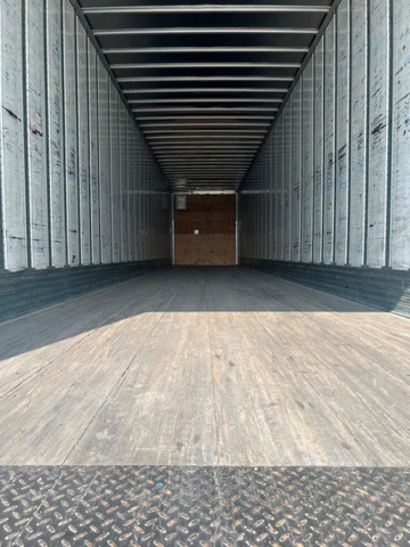 Trailer interior showing empty cargo space in a 2014 utility van/box truck with metal sidewalls and wooden floor.