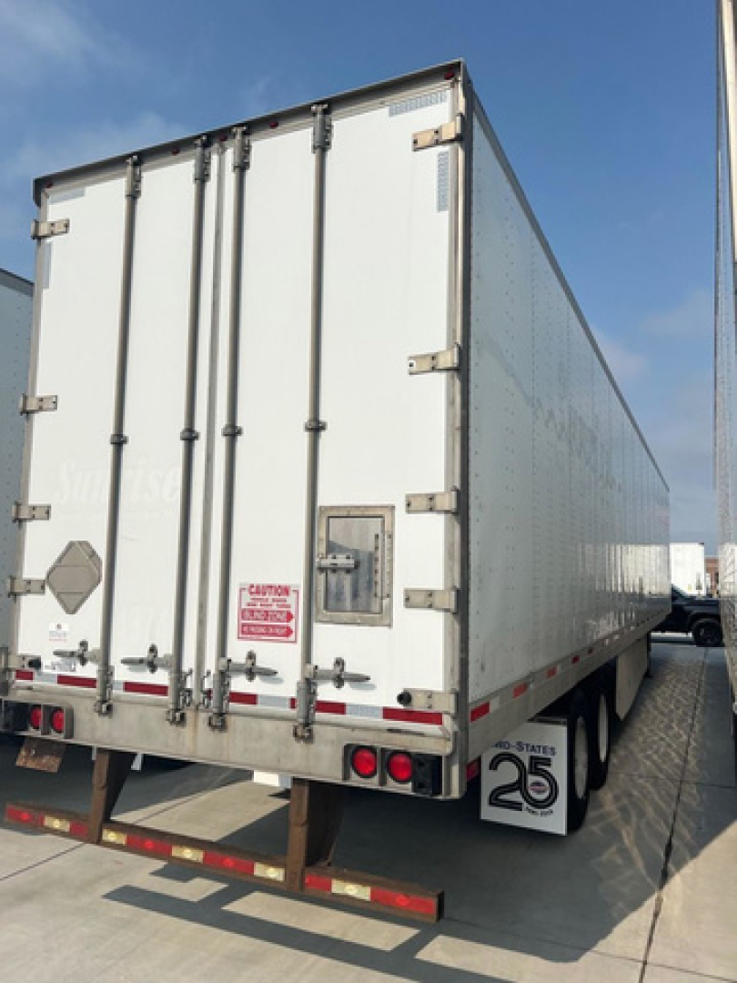 Rear of a 2014 utility van trailer showing double doors, hinge latches, taillights, bumper, and rear wheel area.