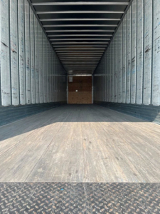 Trailer interior showing empty cargo space in a 2014 utility van/box truck with metal sidewalls and wooden floor.