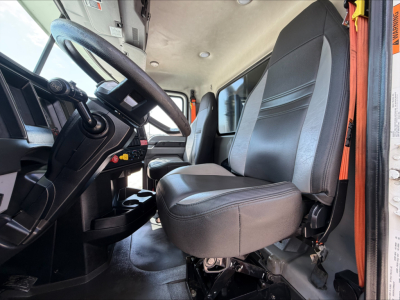 Cab interior of a 2023 Mack GR84F dump truck showing driver and passenger seats, steering wheel, and dashboard.
