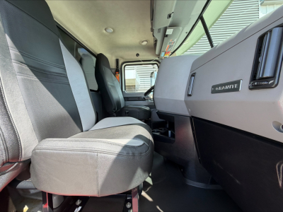 Cab interior of a 2023 Mack GR84F dump truck showing grey and black front seats, dashboard with Mack Nağbni? badge, steering area, and wide windshield
