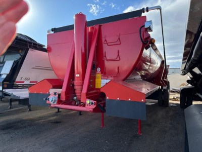 Ranco rock end dump trailer showing red hull with elevated hopper, front hitch, hydraulic system, and support legs.