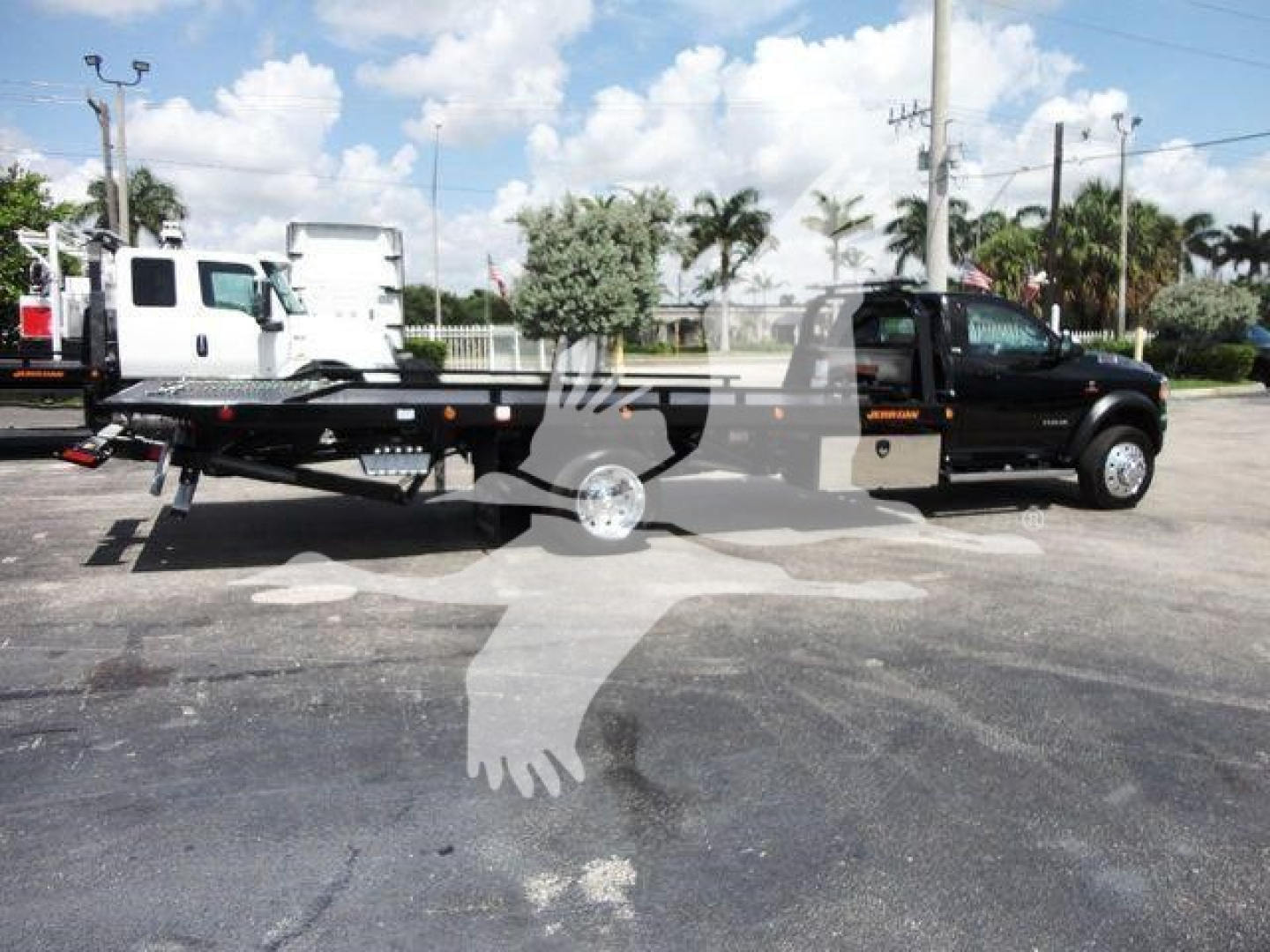 Tow truck bed with Ram 5500 SLT under blue sky, stock number J67261, rollback category, new truck.