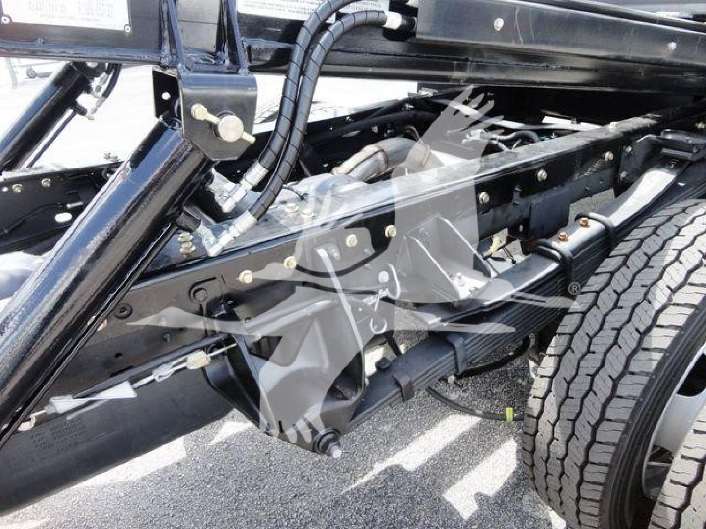 Ram 5500 chassis view showing heavy-duty frame, suspension, and wheel. View focuses on undercarriage with leaf springs and black steel components.