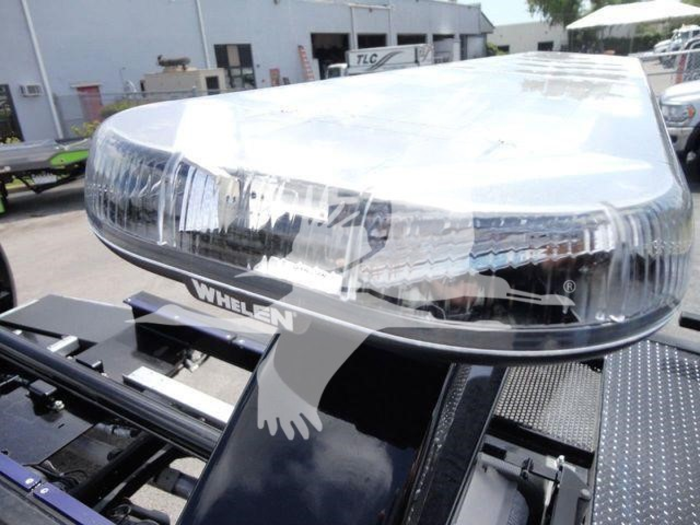 RAM 5500 rollback truck headlight assembly with Whelen light bar on top, chrome grille area, and mounting platform visible.