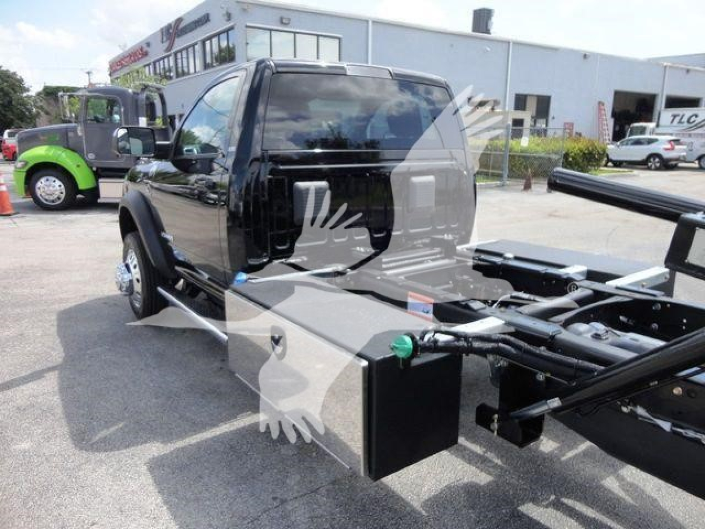 Ram 5500 chassis cab rollback truck with flatbed frame and toolbox showing side view mirrors and cab; stock number J67261.