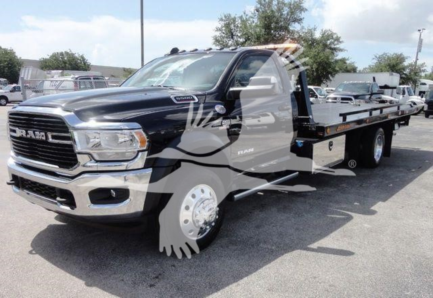 Ram 5500 SLT rollback truck showing front grille and extended flatbed with chrome mirrors and decals.