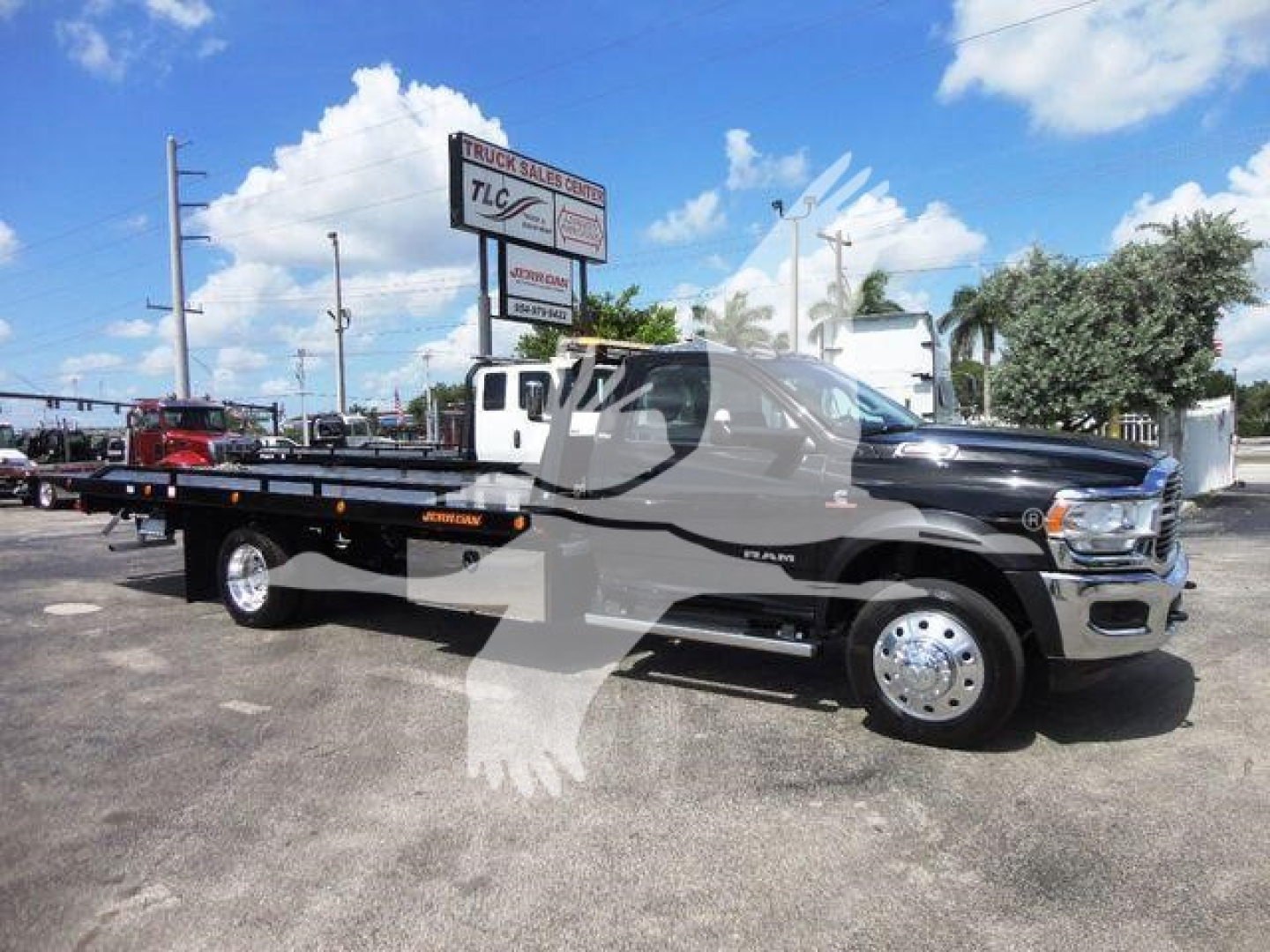 2024 Ram 5500 SLT pickup truck with rollback flatbed, side view, showcasing RAM 5500 badging and chrome wheels.