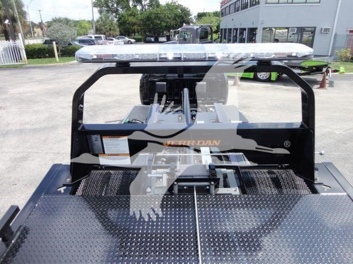 Truck bed with a gooseneck hitch and metal diamond plate, light bar on top, Ram brand branding visible on the hitch frame.