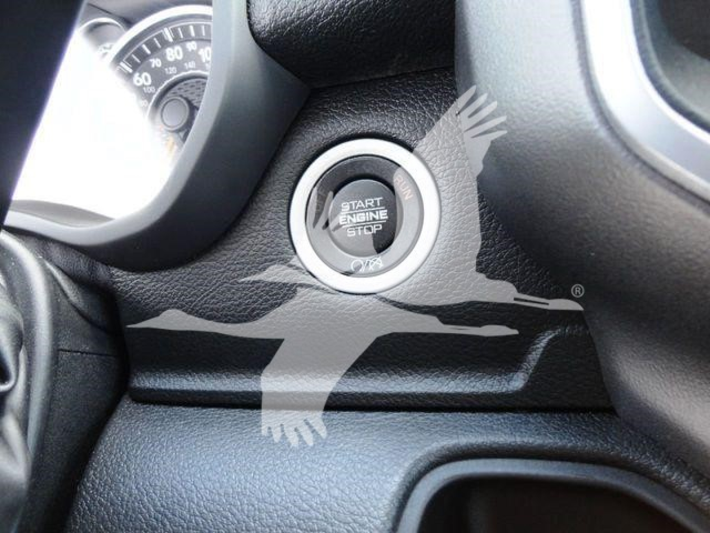 Ram 5500 dashboard area showing start/stop engine button labeled 'START ENGINE STOP' with surrounding textured black dash and partial gauge; no additional labels visible.