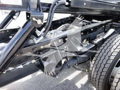 Ram 5500 chassis view showing heavy-duty frame, suspension, and wheel. View focuses on undercarriage with leaf springs and black steel components.