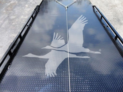 Flatbed truck bed with diamond plate surface featuring a large white graphic of two geese in flight along the center seam.