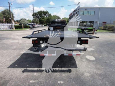 Ram 5500 rollback flatbed truck rear view showing flatbed with dual taillights and bumper platforms.