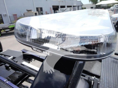 RAM 5500 rollback truck headlight assembly with Whelen light bar on top, chrome grille area, and mounting platform visible.