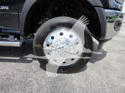 Ram truck front wheel showing chrome hub with multiple lug nuts and star emblem, tire mounted, fender and side step visible.