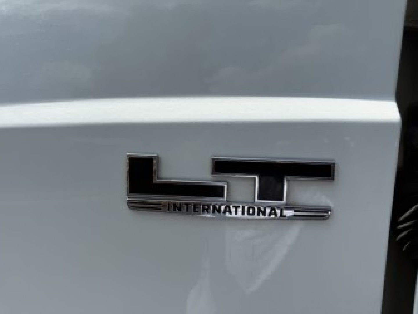 LT International emblem on the side of a 2021 International LT625 truck cab side panel, with 'INTERNATIONAL' and 'LT' chrome badge visible.