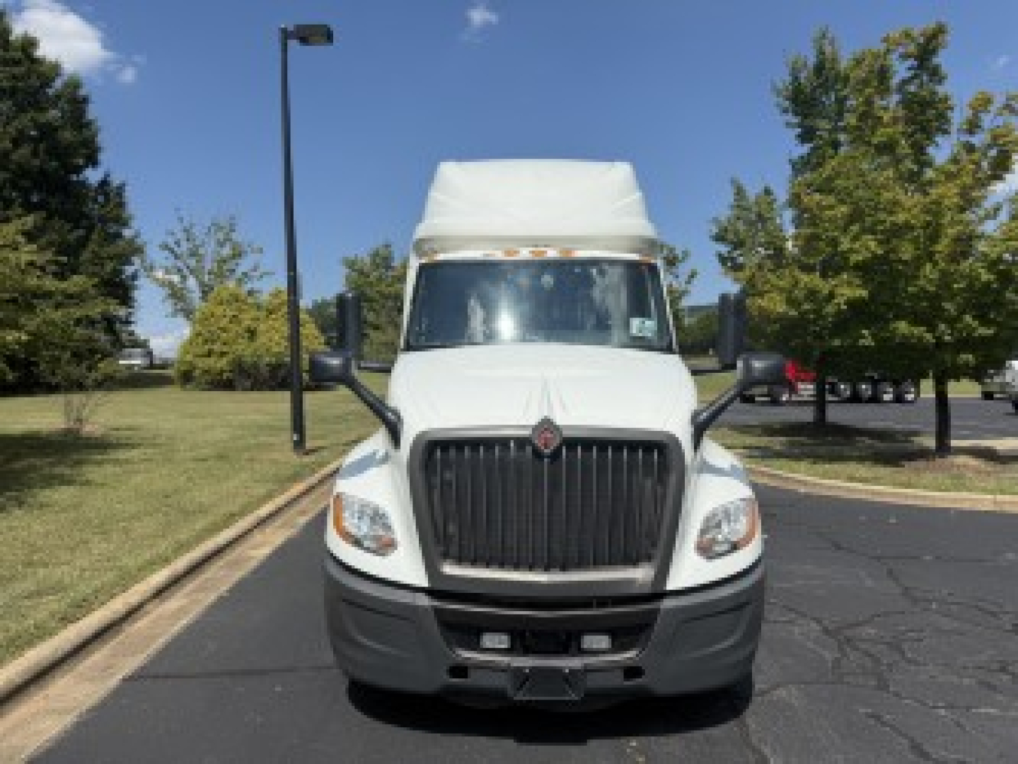 International LT625 truck cab front view with large grille and white sleeper top.