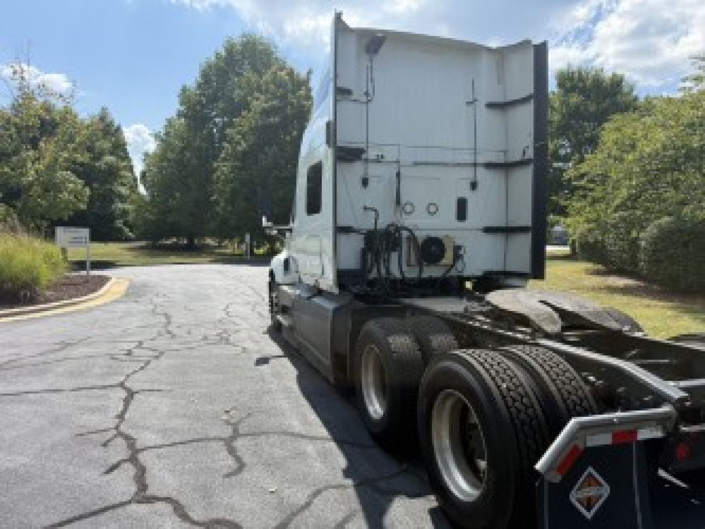 Rear view of a white 2021 International LT625 semi-truck tractor in sleeper configuration, showing rear trailer hitch area with fifth wheel and dual rear axles.