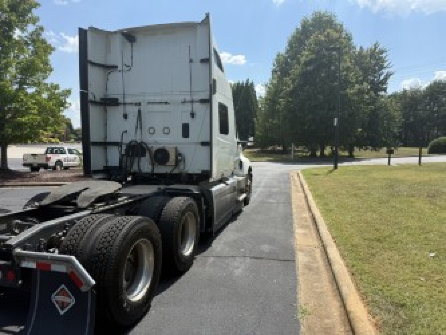 International LT625 semi truck rear view showing sleeper cab and dual rear axles with tires.