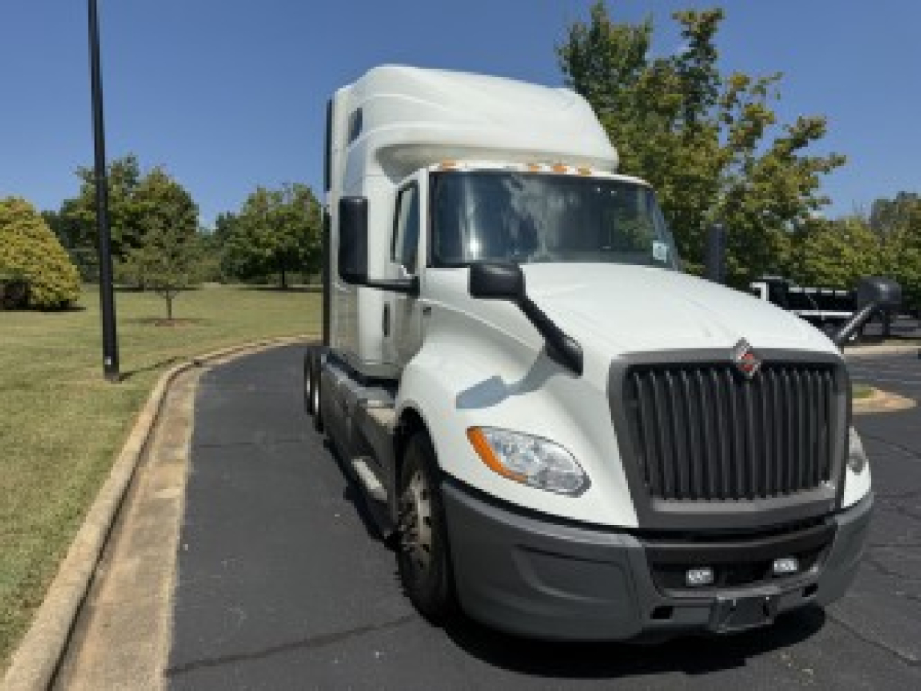 International LT625 sleeper cab truck in white showing front grille and headlights.