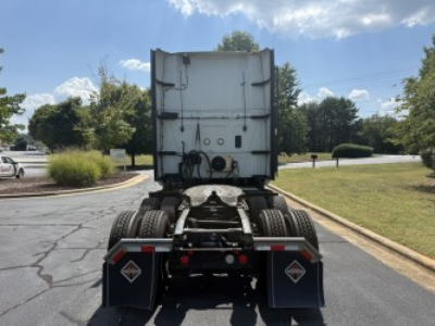 Rear view of a used 2021 International LT625 tractor with fifth wheel and dual rear axles, showing decals and mud flaps.