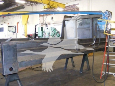 Dump truck bed frame with hydraulic hose and control area in workshop, 14 ft Advanced Fabricators model under assembly.