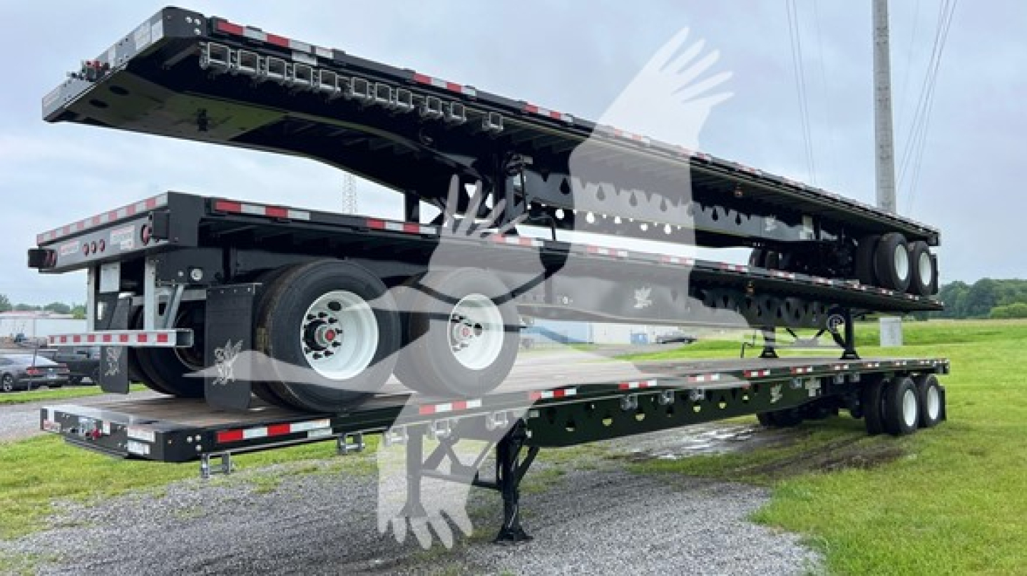 Manac steel flatbed trailer with S/R slider in extended position on a dual-axle trailer.
