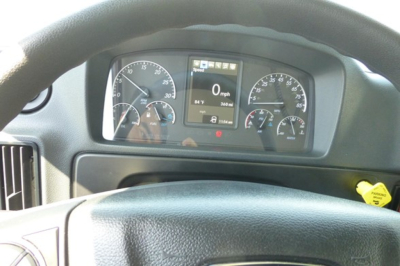 Dashboard view of a Freightliner cab showing analog gauges and a central digital display with speed reading 0 mph.