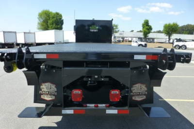 Freightliner 114SD Plus flatbed truck rear view showing dual red taillights, rear bumper, and mud flaps with Peach State 50 years logo.