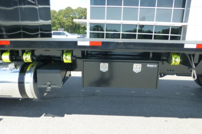 Freightliner 114SD Plus truck rear showing black toolbox with silver badges and yellow straps, undercarriage and fuel tank visible.