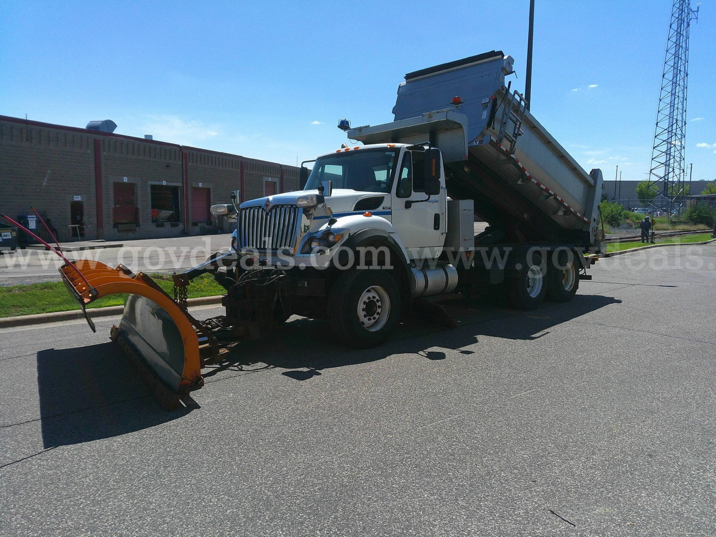 2008 International 7600 dump truck with plow attachment and dump bed, side view.