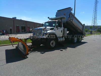 2008 International 7600 dump truck with plow attachment and dump bed, side view.