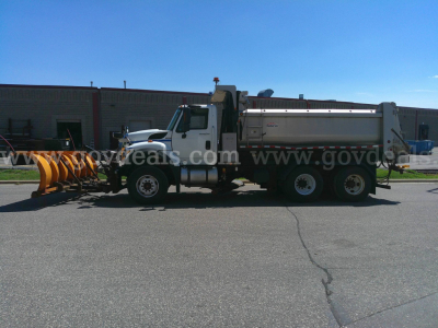 Truck with plow and dump body side view showing International 7600 chassis.