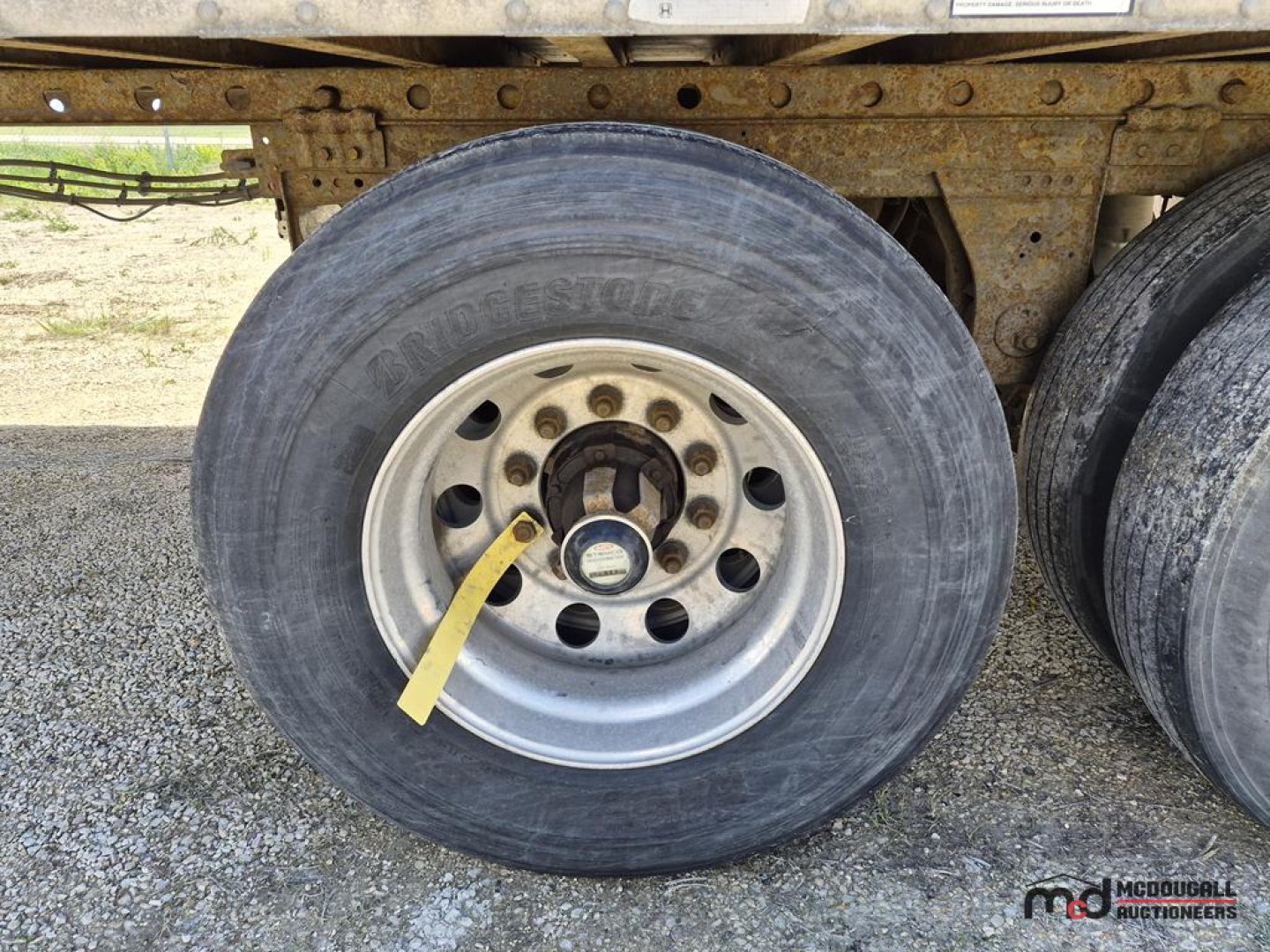 Trailer wheel area showing Bridgestone tire and steel rim of a 53' dry van trailer undercarriage.