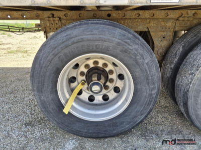 Trailer wheel area showing Bridgestone tire and steel rim of a 53' dry van trailer undercarriage.