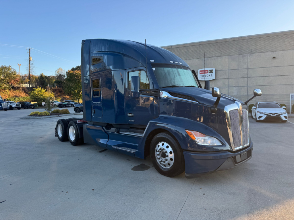 Kenworth T680 truck in blue, side view, with sleeper cab and front grille visible.
