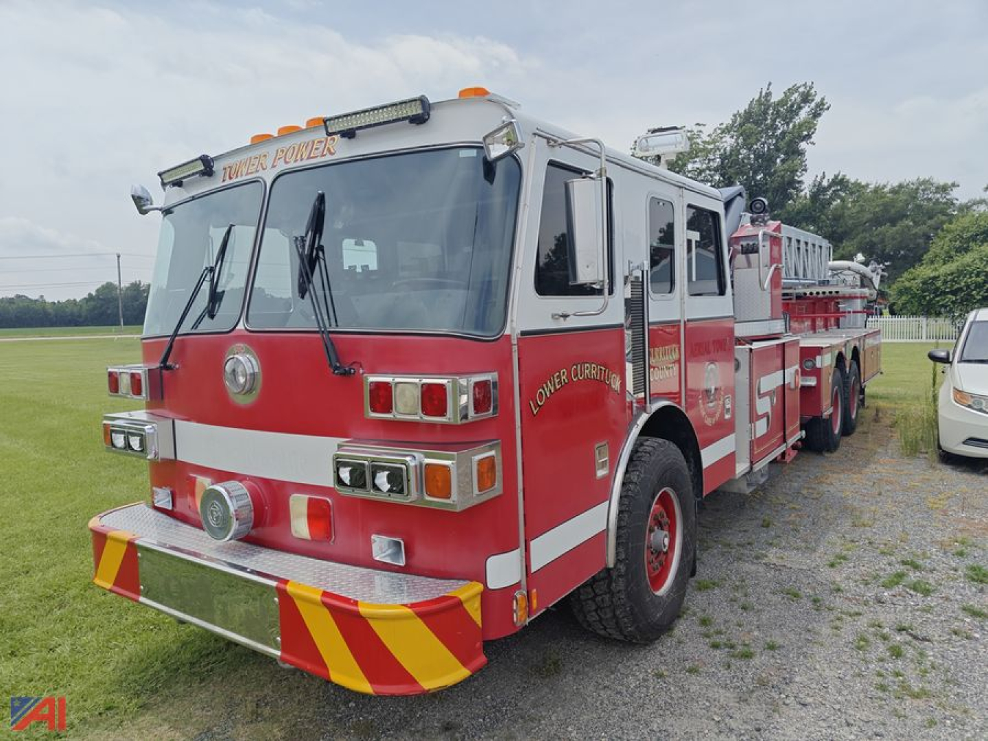 Fire truck with red body and white cab, twin ladders, water hoses on side, front bumper and light bars. Text on cab reads 'LOWER CUMBER' and 'TOWER POWER' on top; side shows 'LOWER CUMBER' near door and emergency markings.