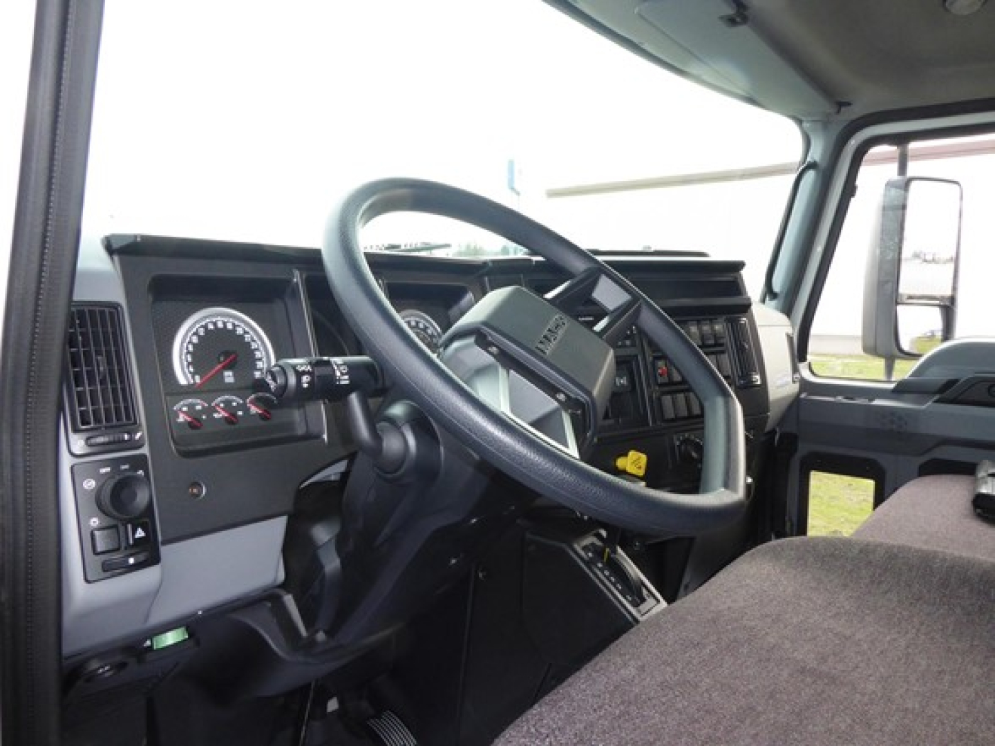 Mack MD6 truck cab interior showing steering wheel, instrument cluster, and dashboard with gauges and controls.