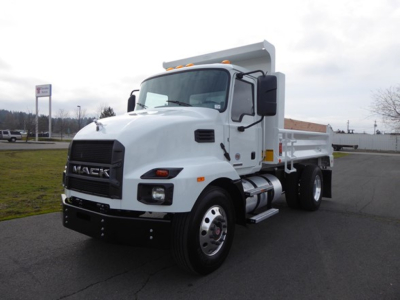 Mack MD6 dump truck in a parking lot, front-left view showing cab and white dump bed.